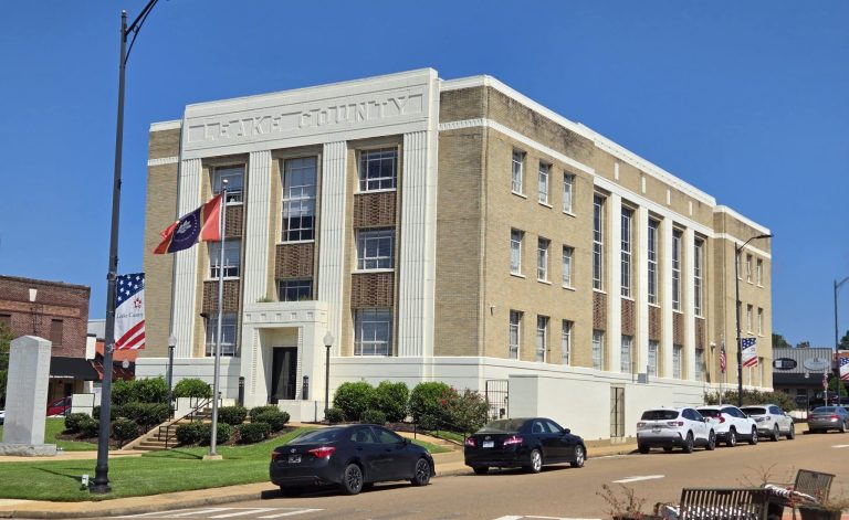 Clarke County courthouse with flags and cars outside.